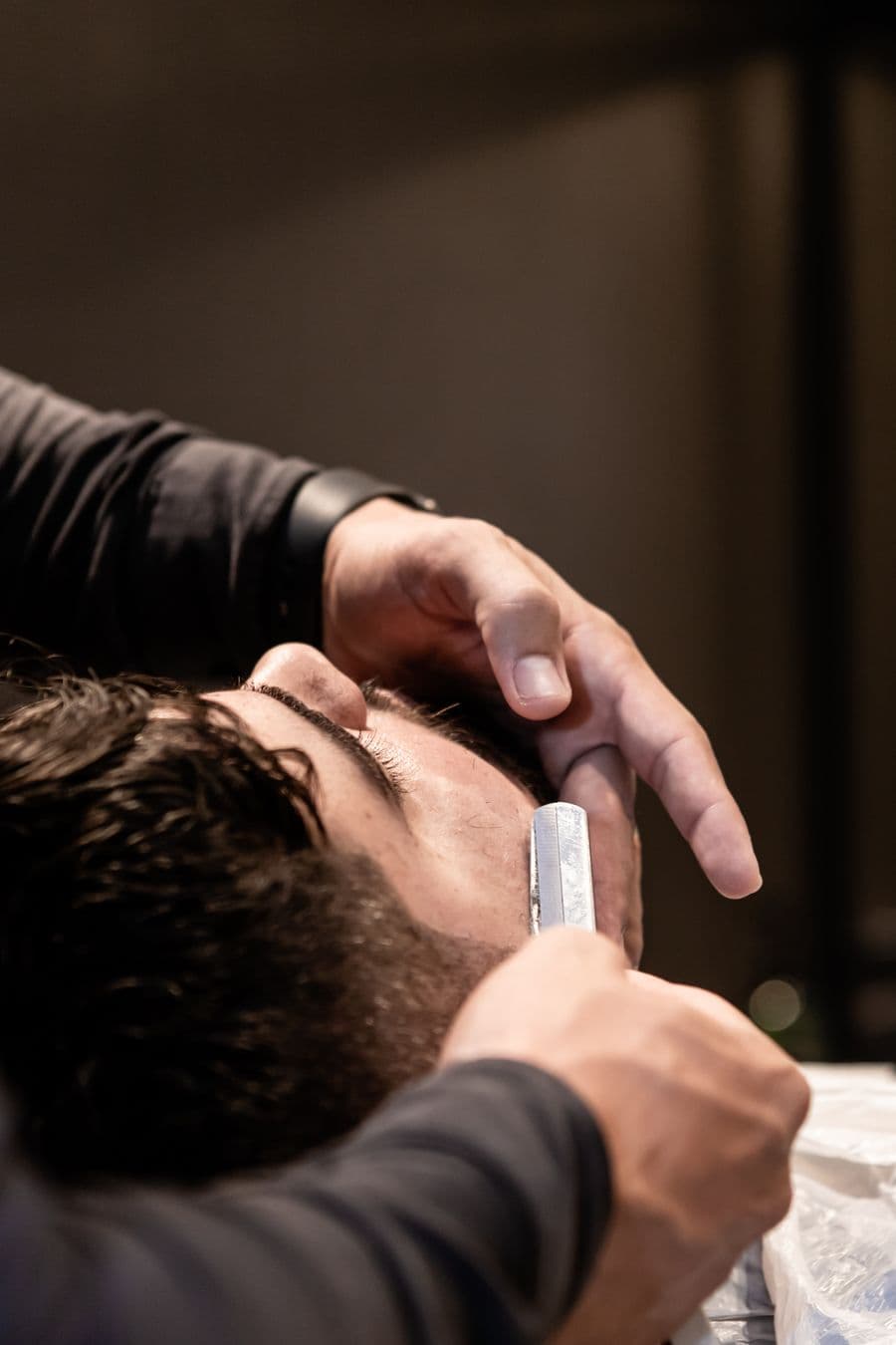 Barber lining up a beard with a straight razor
