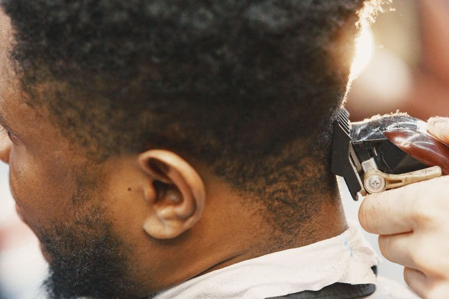 Barber trimming a client's hair with clippers