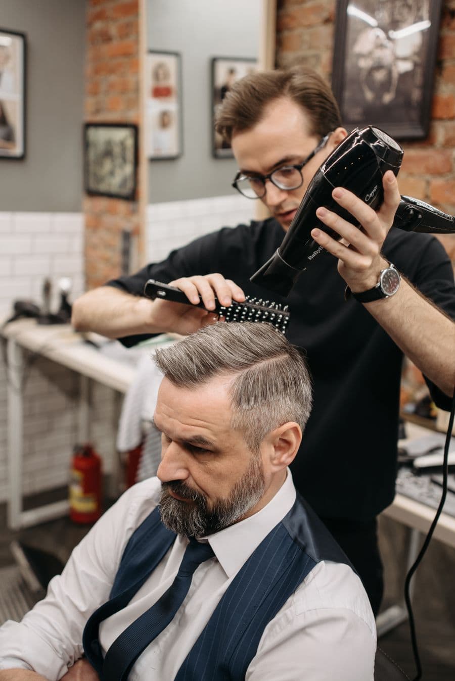 Barber blow-drying and styling a finished cut
