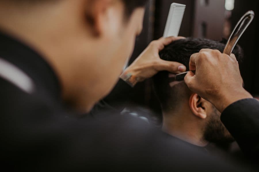 Barber restyling a client's hair with a comb